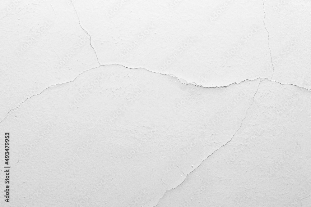Naklejka premium The white concrete wall is cracked, the paper is cracked