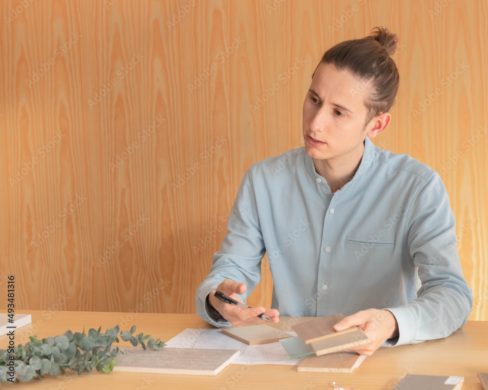 Man interior designer showing customers material samples for their home