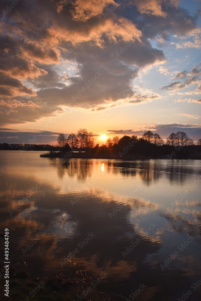 Wonderful morning landscape in Poland. The sun over the lake in a colorful sky.