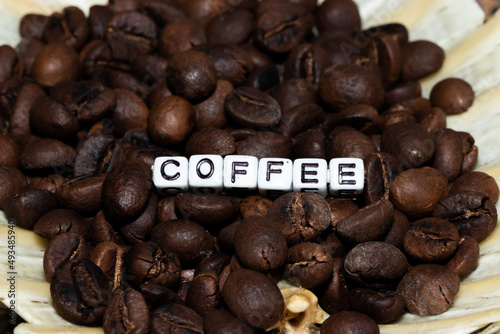 Mote alphabet blocks arranged to write  coffee  on coffee beans.