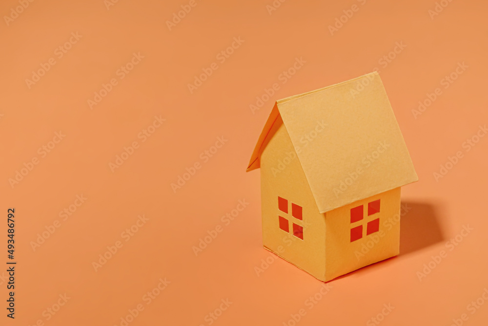 Orange paper house with copy space. The concept of buying a sale and a loan for a house. Minimal concept and pastel color.