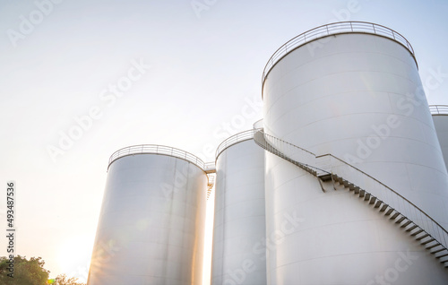 Curved stairway of base oil storage tank in the petroleum factory with blue sky. Industrial petroleum plant. Base oil for automotive engine oil and industrial oil application. photo