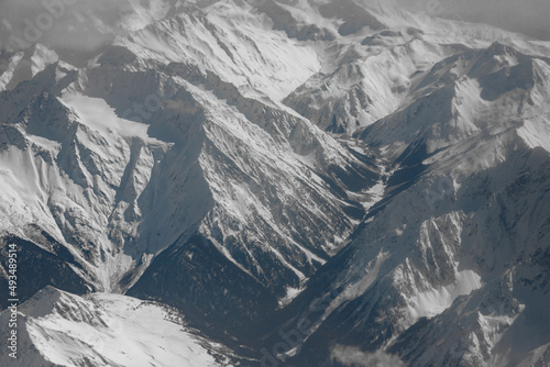 View from the plane. Mountains covered with snow. Clouds and mountains. Journey.