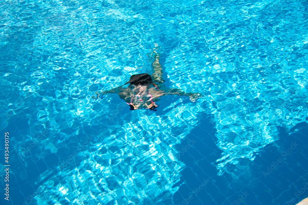 woman swimming under blue sea water. underwater