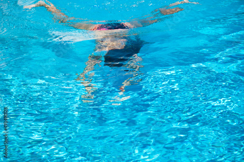 woman swimming under blue water. summer vacation. underwater
