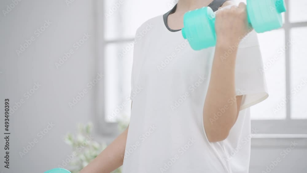 ダンベルを使って筋トレをする女性 ダンベルを使って筋トレをする女性