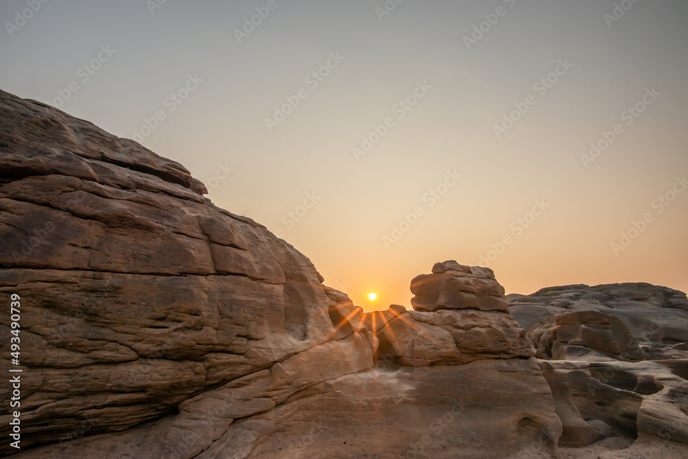 Sunrise at three thousand waved rocks under the natural sandstone group of the Mekong River that has been eroded for a long time in Ubon Ratchathani, Thailand.