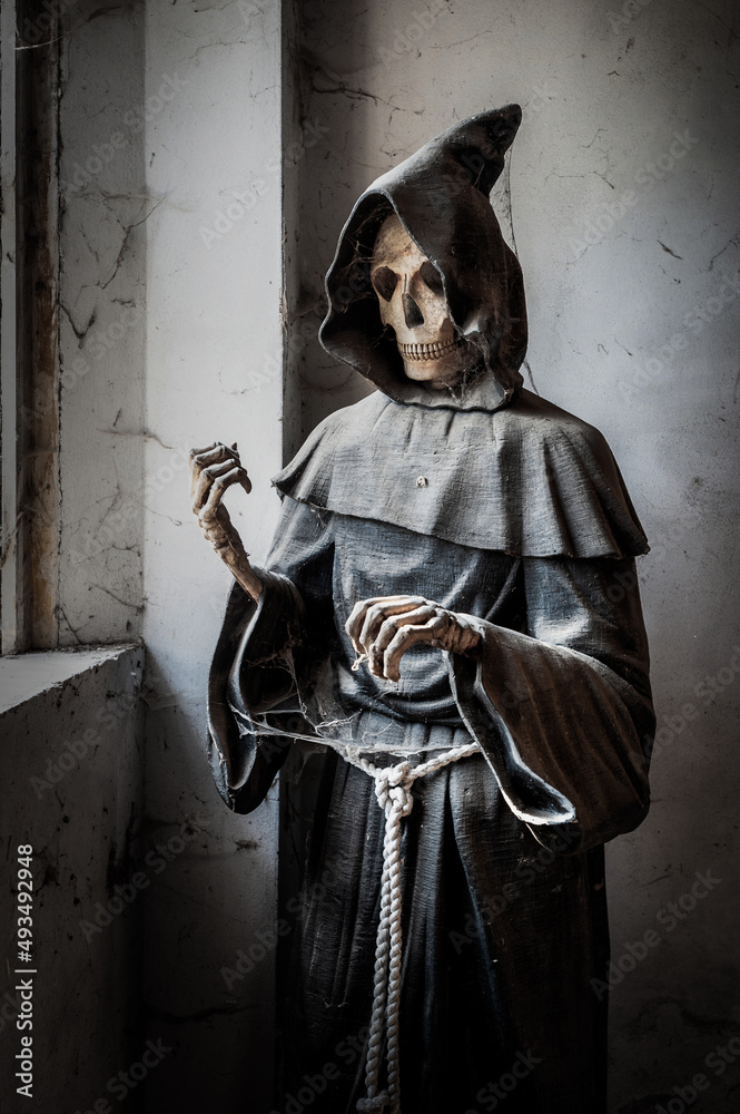 Naklejka premium November 2021, Urbex Italy, disturbing statue depicting death, in an abandoned house