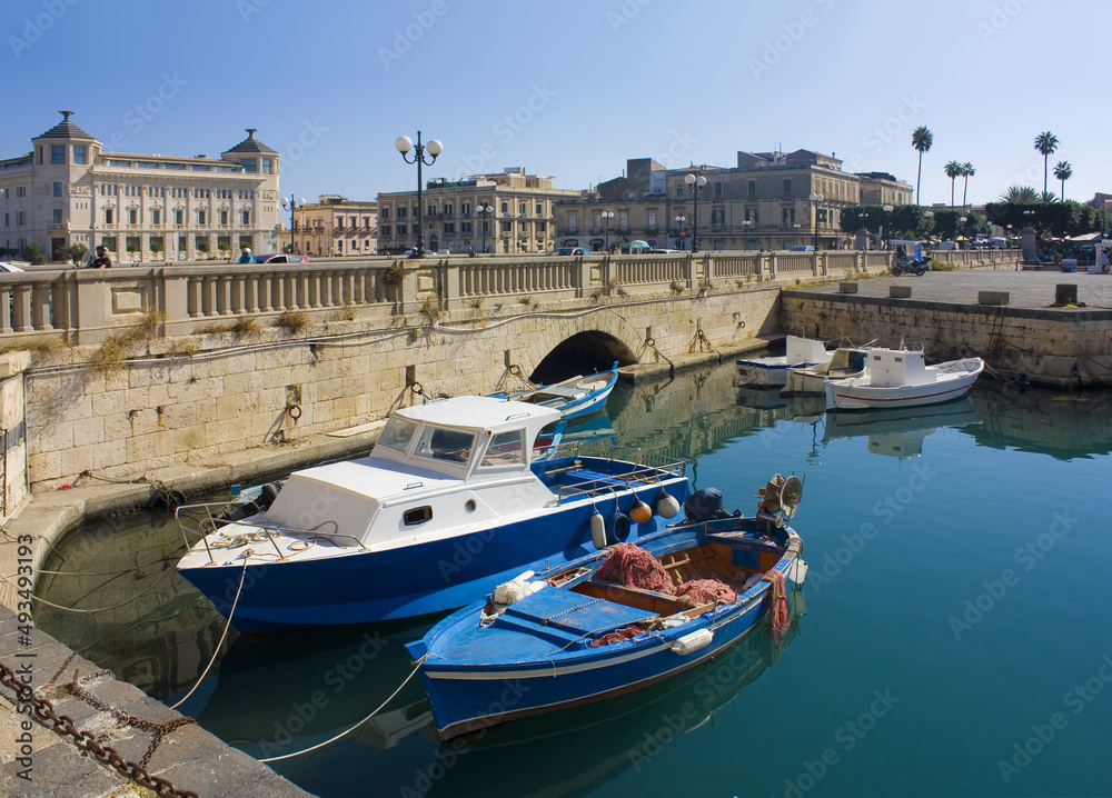 Boats are moored next to the old town of Syracuse, Sicily