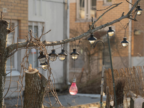 Old lanterns hang on a branch. Ruined yard. Broken windows.