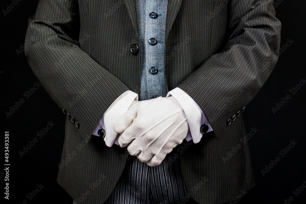 Closeup of Butler in Formal Suit and White Gloves Standing at Respectful Attention. Concept of Service Industry and Professional Courtesy and Care.