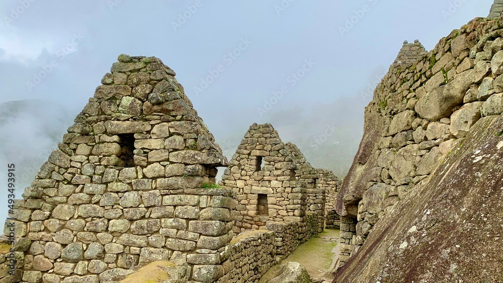 ruins of the ancient city of machu picchu with clouds over the mountain