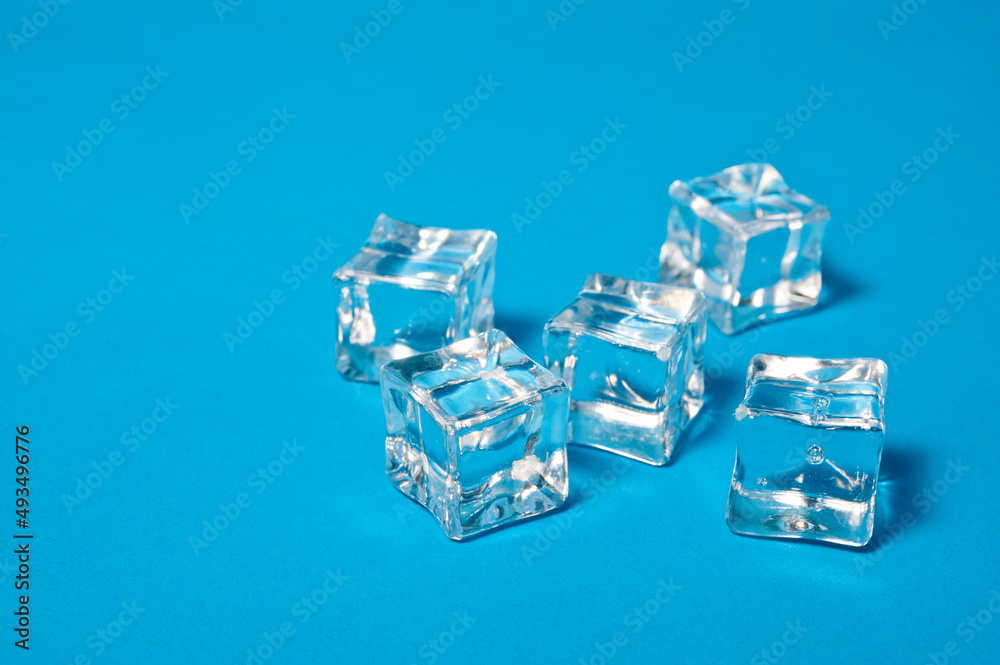 Clear ice cubes for cooling drinks on a blue background. Clear ice cubes for cooling drinks on a blue background.