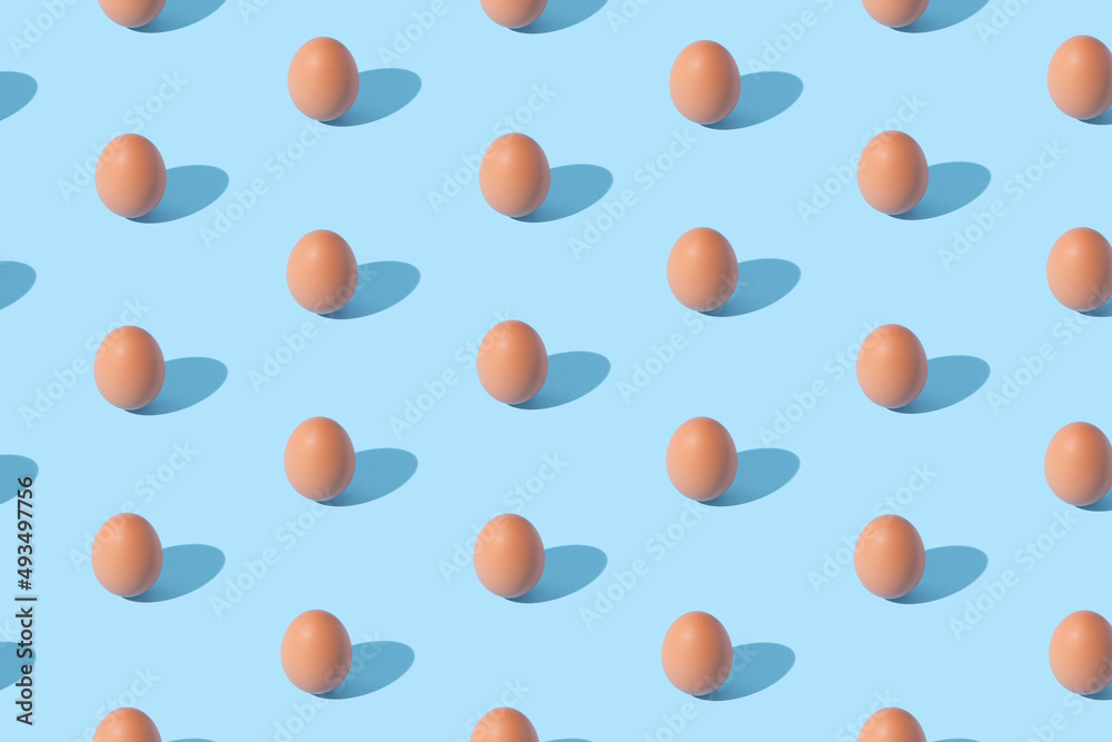 Pattern made of eggs on pastel blue background. Minimal food concept.