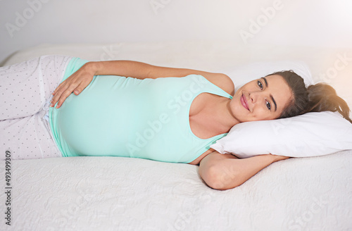I cant wait to meet my baby. Shot of a pregnant woman relaxing on her bed at home.
