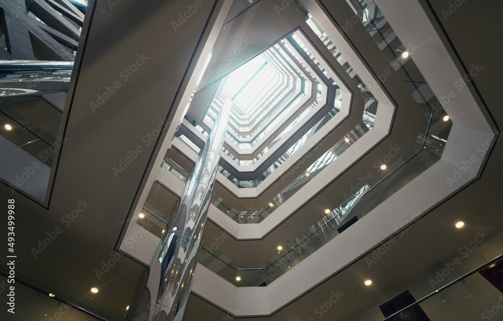 Fototapeta premium View from below of interior structure in metal and glass of an empty modern building without people
