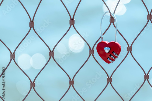 Love forever.-  red heart shaped lock on a fence