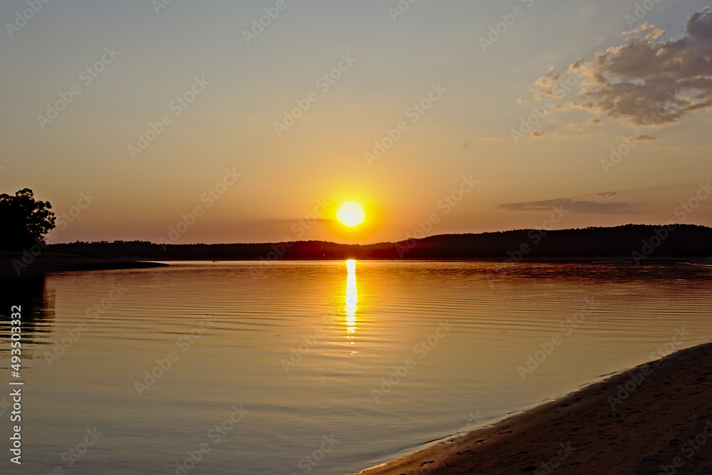 Warm orange sunset sky over Montargil lake, Portalegre, Portugal