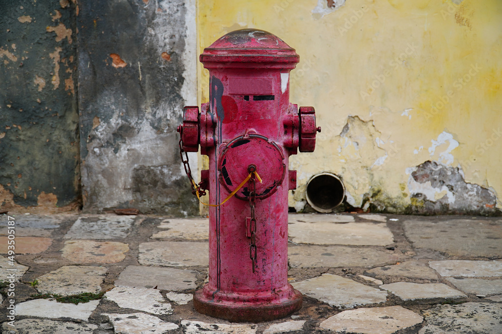 Red purple colored old fire hydrant in the historic old town of Sao Luis, Maranhao, Brazil. Red purple colored old fire hydrant in the historic old town of Sao Luis, Maranhao, Brazil.