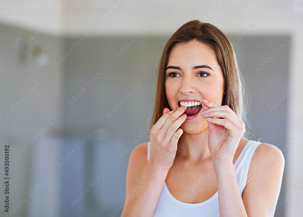 Taking good care of her teeth. Cropped shot of a beautiful young woman flossing her teeth. Taking good care of her teeth. Cropped shot of a beautiful young woman flossing her teeth.