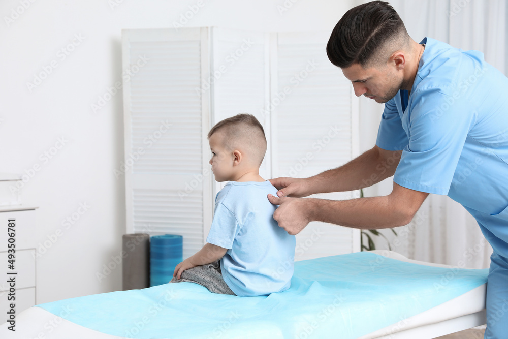 Orthopedist examining child's back in clinic. Scoliosis treatment Orthopedist examining child's back in clinic. Scoliosis treatment