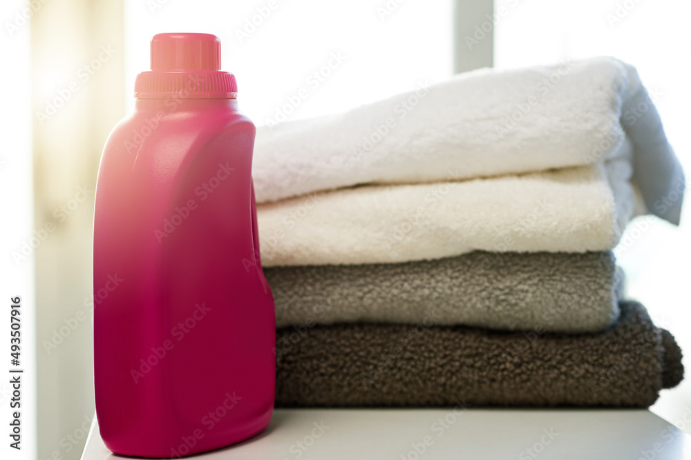 Who doesnt love clean towels. Shot of a bottle of detergent alongside a pile of folded towels at home. Who doesnt love clean towels. Shot of a bottle of detergent alongside a pile of folded towels at home.