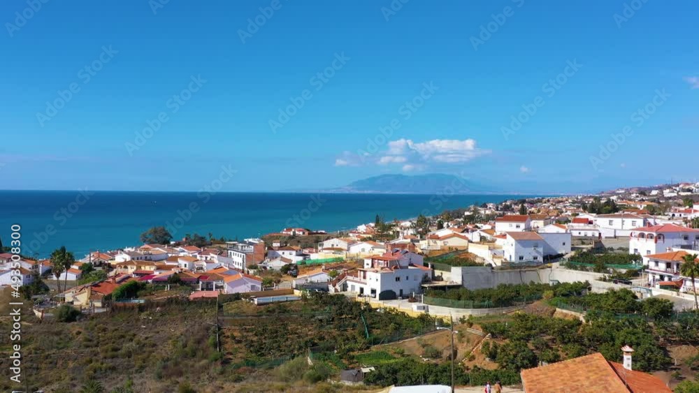 Fly over the village in the region of Malaga Andalusia Benajarafe Spain. Village of white houses on the shores of the Mediterranean Sea. Mediterranean landscape with beach and sunset. Malaga Spain Fly over the village in the region of Malaga Andalusia Benajarafe Spain. Village of white houses on the shores of the Mediterranean Sea. Mediterranean landscape with beach and sunset. Malaga Spain