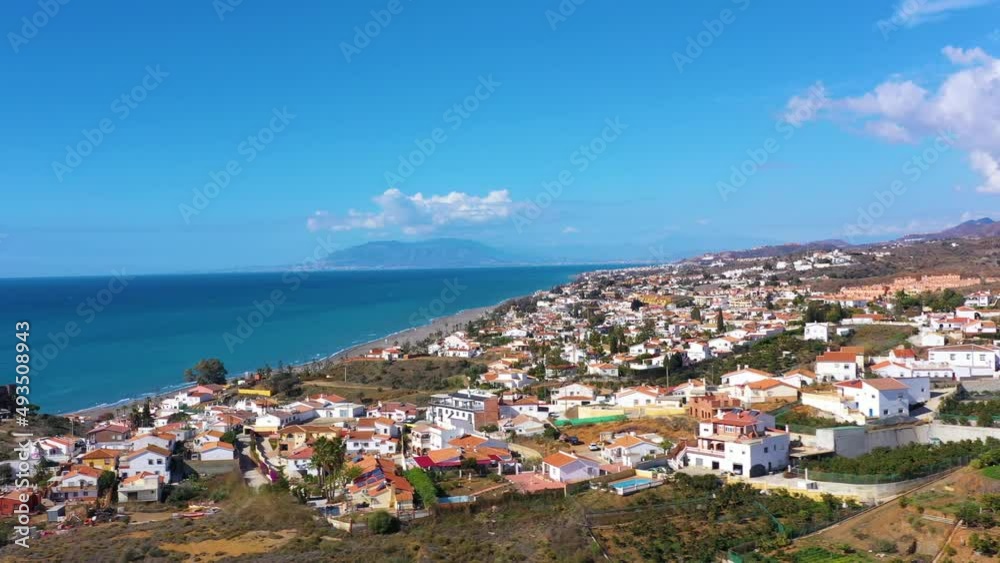 Fly over the village in the region of Malaga Andalusia Benajarafe Spain. Village of white houses on the shores of the Mediterranean Sea. Mediterranean landscape with beach and sunset. Malaga Spain Fly over the village in the region of Malaga Andalusia Benajarafe Spain. Village of white houses on the shores of the Mediterranean Sea. Mediterranean landscape with beach and sunset. Malaga Spain