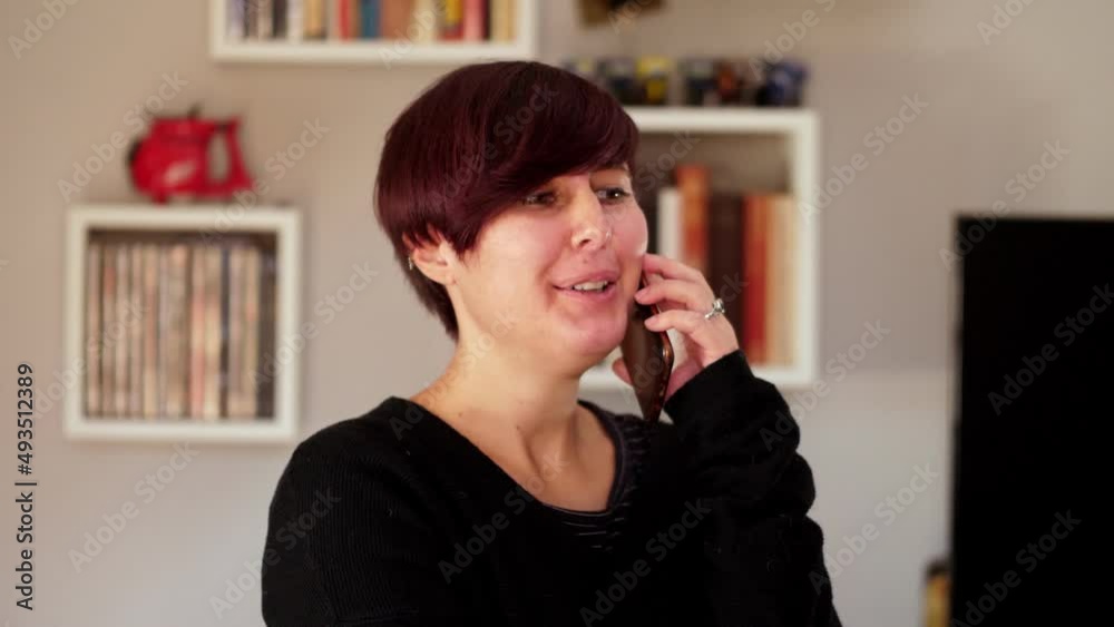 Attractive young woman using smartphone at home. She is talking to her best friend Attractive young woman using smartphone at home. She is talking to her best friend