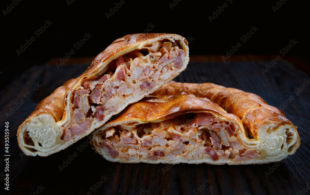 Meat village pie lies on a wooden surface. Meat village pie lies on a wooden surface.