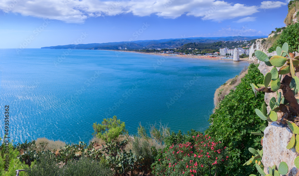 Obraz premium Gargano coast: bay of Vieste in Apulia, Italy. Castello or Scialara beach: it is overshadowed by the Swabiam Castle and the Pizzomunno Monolith (from the local dialect: peak of cape of the world).