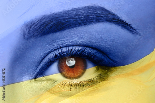 Double exposure of national flag and young woman, closeup of eye. Stop war in Ukraine