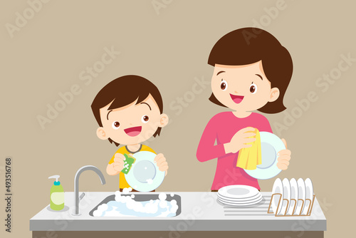 cute little boy washing dish with mother