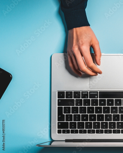 Overhead view of the working woman hands typing on keyboard notebook laptop computer at the colorful background office desk