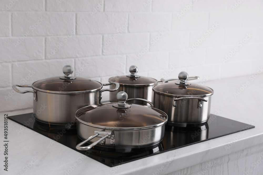 Set of new clean cookware on cooktop in kitchen Set of new clean cookware on cooktop in kitchen