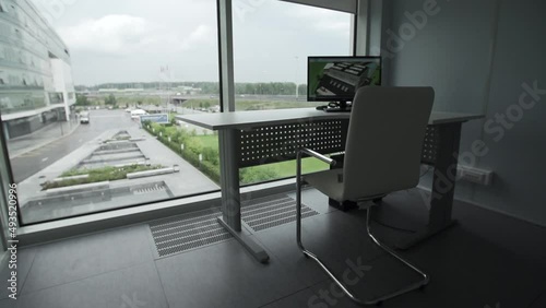 Minimal background image of empty office workplace by window with white desk behind glass wall, copy space. Lost work, unemployment, economic crisis concept.