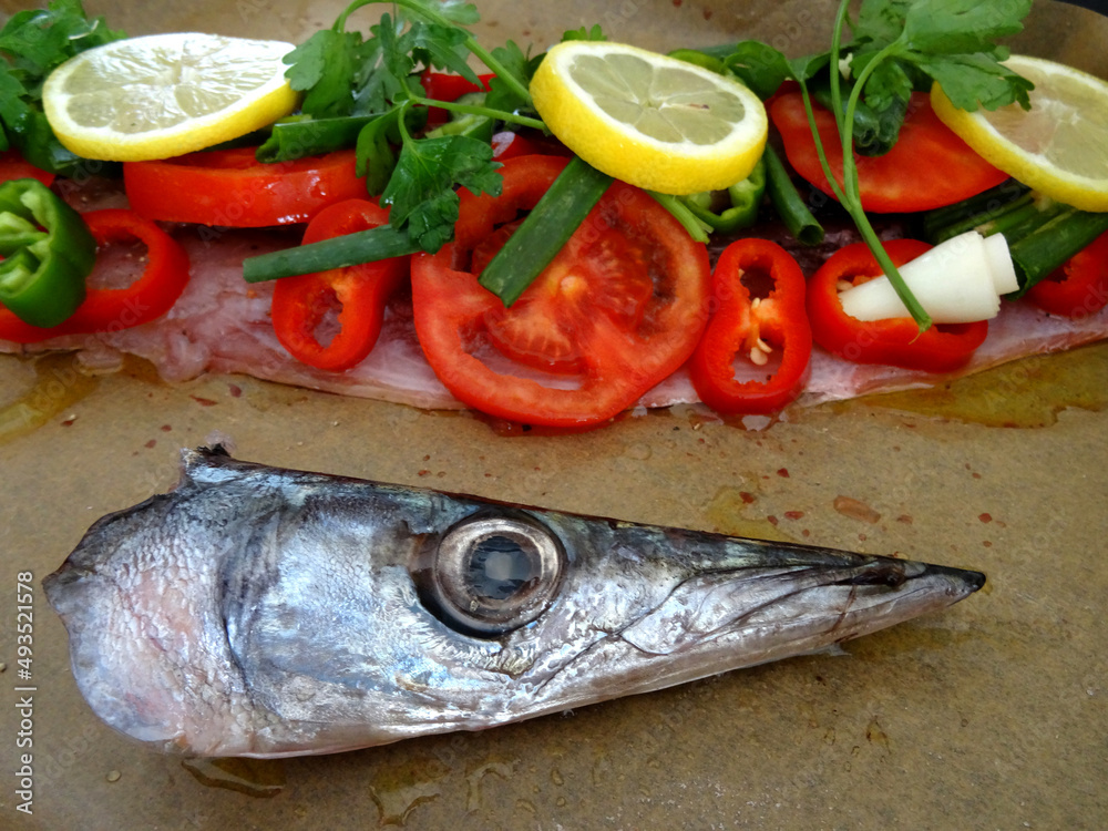 Ready to grill European barracuda (locally known as iskarmoz, known also as mediterranean barracuda, Sphyraena sphyraena) dish prepared with vegetables in Bodrum, Turkey. Ready to grill European barracuda (locally known as iskarmoz, known also as mediterranean barracuda, Sphyraena sphyraena) dish prepared with vegetables in Bodrum, Turkey.