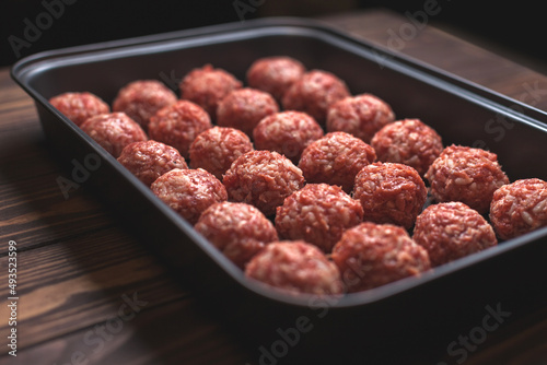 Raw meatballs on Baking trays are prepared and ready for baking in the oven. selective focus