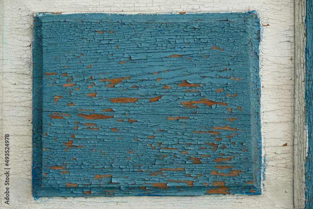 Naklejka premium Close-up of flaking blue paint on a wooden door