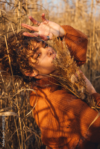 Portrait of a beautiful young woman posing outdoor with her arm over her head