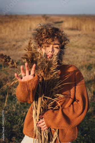 Portrait of a beautiful young woman enjoying the sun with her hand outstretched in front of her