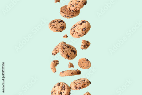 Chocolate chip cookie on a green background. Aesthetic sweet food concept. Flying chocolate biscuits with copy space