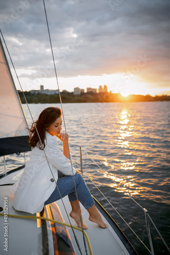 Bachelorette party on a yacht, a beautiful girl on a walk along the river. setting sun © Denys