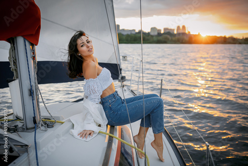 Bachelorette party on a yacht, a beautiful girl on a walk along the river. setting sun © Denys