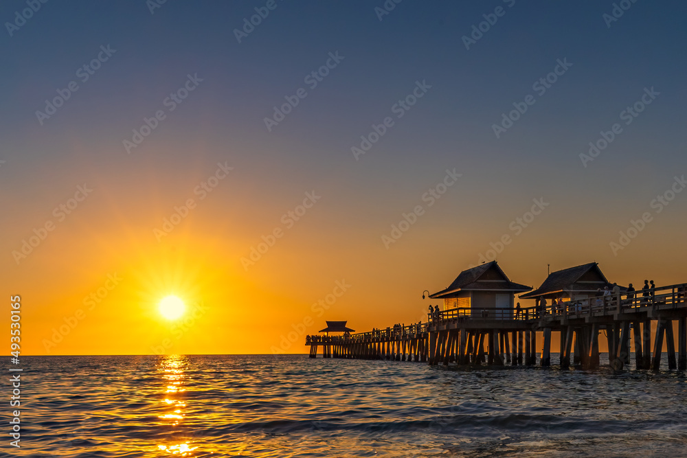 A perfect day winds down with a brilliant sunset, over the Gulf of Mexico, at the pier in Naples Florida.