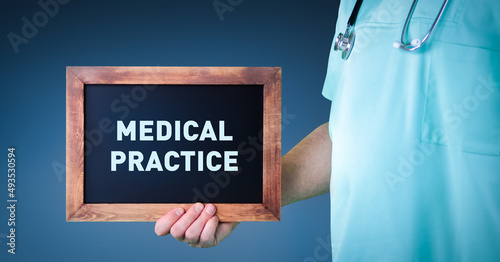 Medical Practice. Doctor shows sign/board with wooden frame. Background blue photo