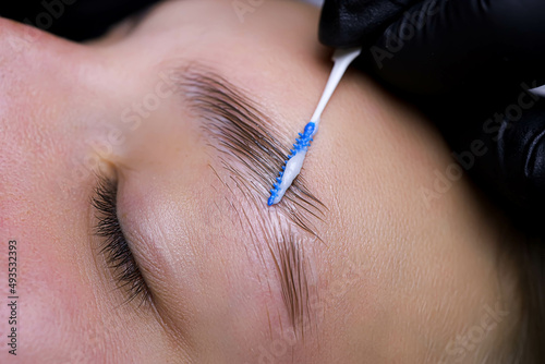 close-up of eyebrow hairs styled and combed with laminating compositions photo