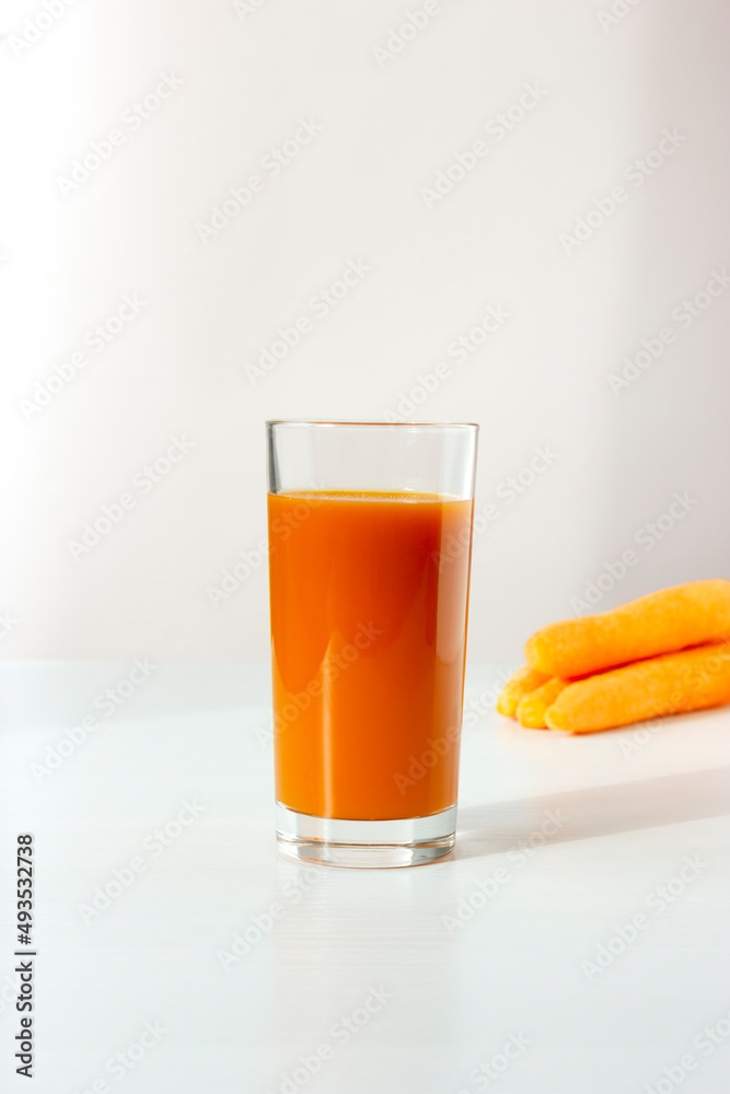 Healthy drink: glass of fresh carrot juice and fresh carrots isolated on white. Vertical plane. Copy space. Healthy drink: glass of fresh carrot juice and fresh carrots isolated on white. Vertical plane. Copy space.