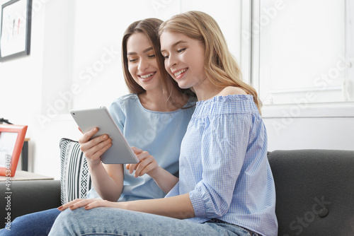 Young sisters using tablet ...