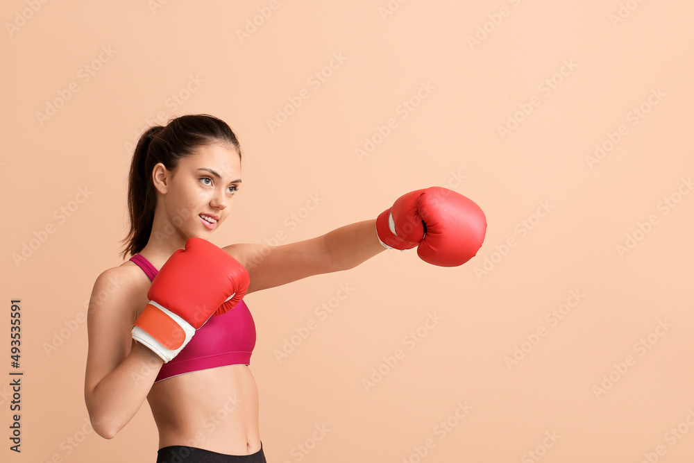 Sporty teenage girl with boxing gloves on beige background Sporty teenage girl with boxing gloves on beige background